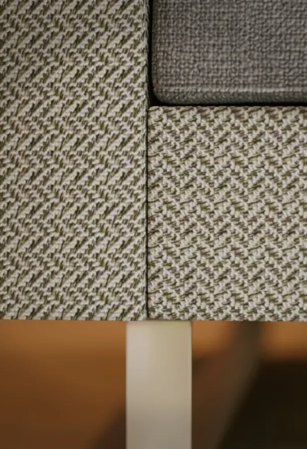 Hochwertige Stoffstruktur und klare Linien eines komfortablen Sofas. Fokus auf Materialqualität, Ergonomie und langlebigen Wohnkomfort. Detailaufnahme hochwertiger Sofatextur – komfortables, körperfreundliches Wohnen